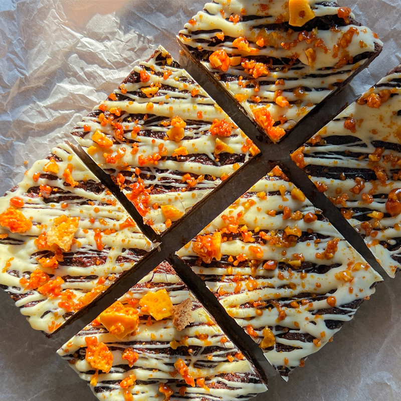 Six squares of vegan brookies with white choc drizzled on top and honeycomb pieces